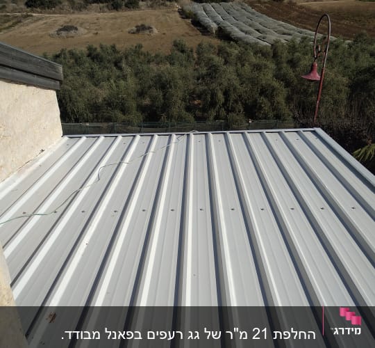 גג מתכת עם כבל ירוק מונח עליו